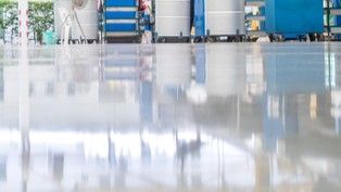 High-gloss Floor Reflects Industrial Storage Units and Equipment in a Clean Warehouse — Western Epoxy Works In Dubbo, NSW