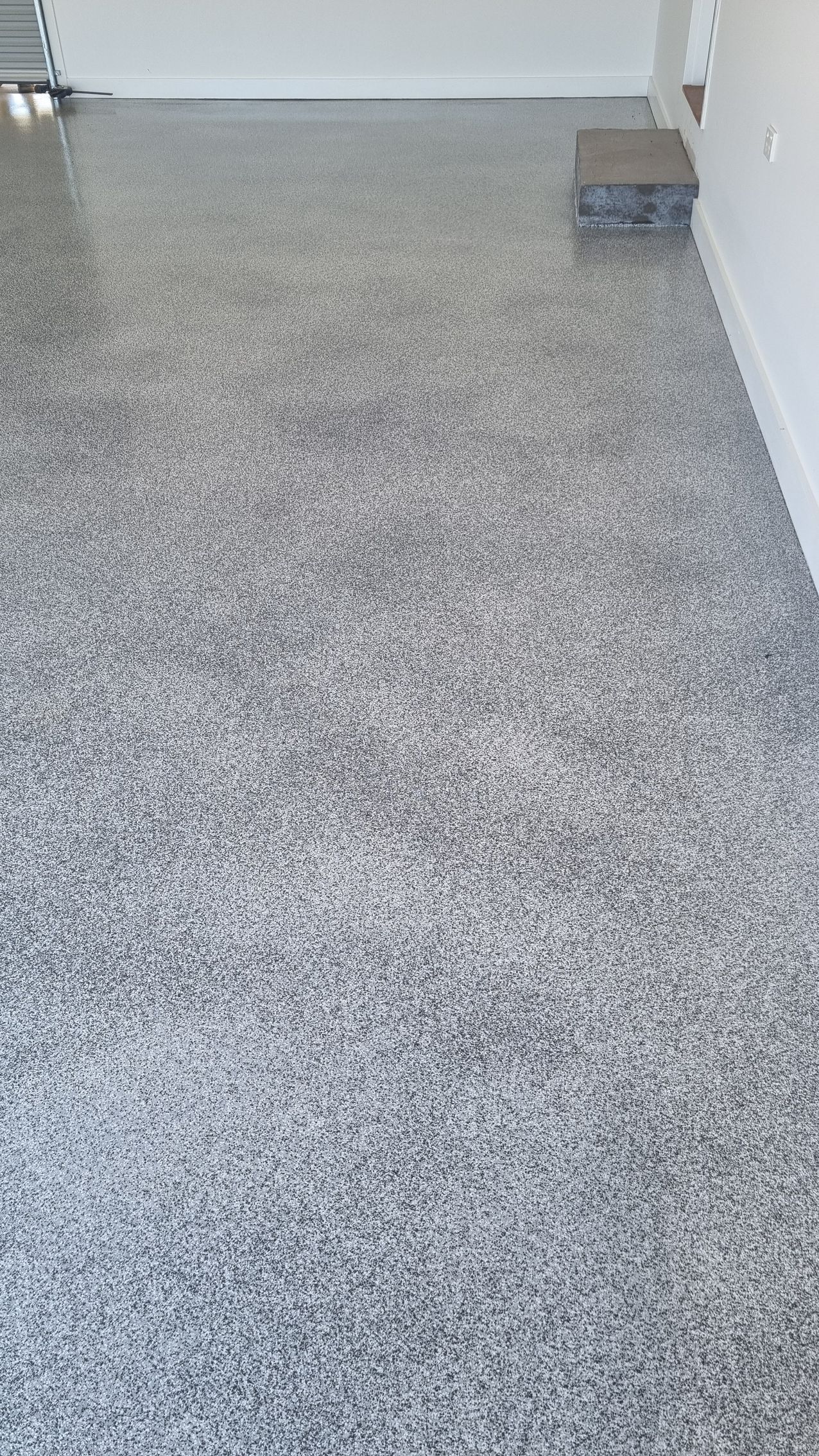 A Person Uses a Metal Trowel to Smooth Bright Blue Epoxy Resin Over a Floor Surface — Western Epoxy Works In Dubbo, NSW