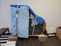 Covered recliner chair with blue blankets and straps in a small room