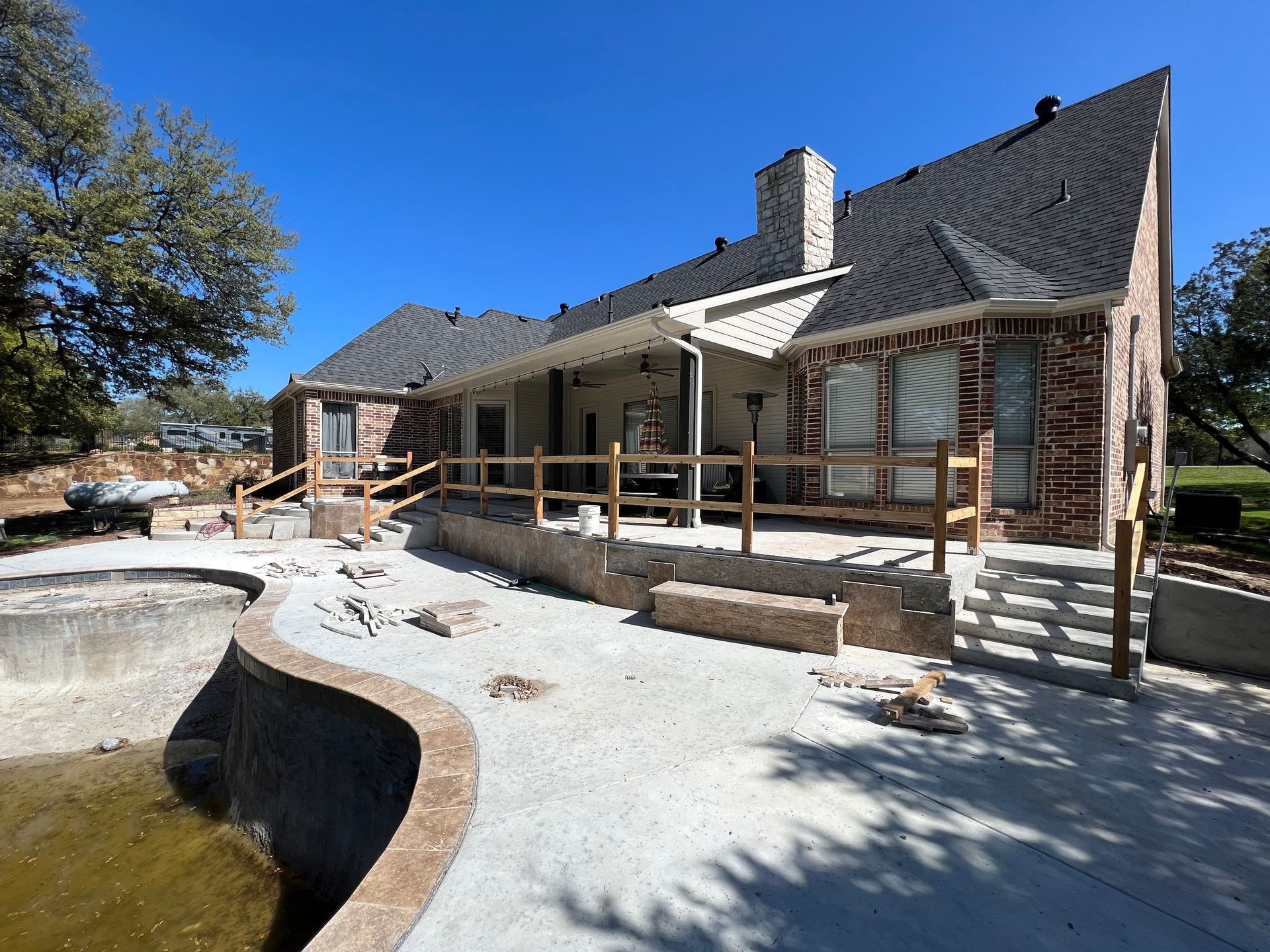 A large brick house with a swimming pool in front of it.