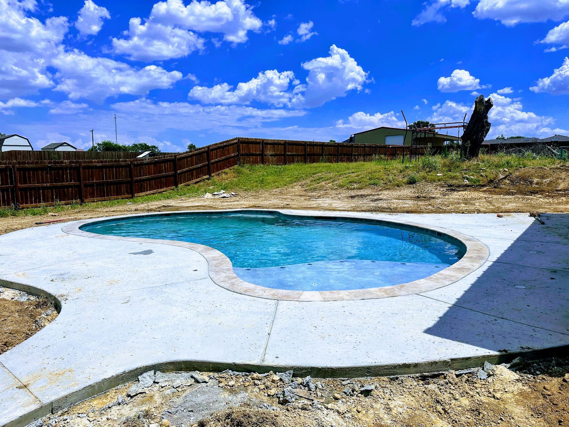 A swimming pool is being built in the backyard of a house.