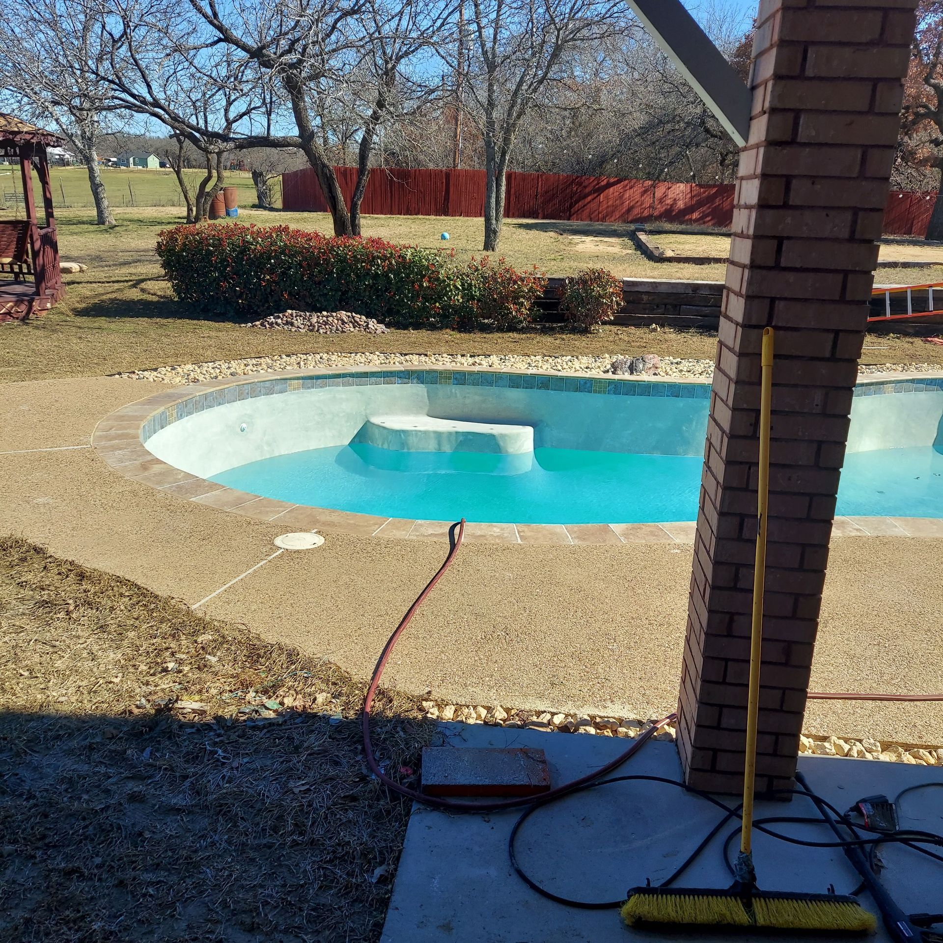 A swimming pool with a yellow broom in front of it