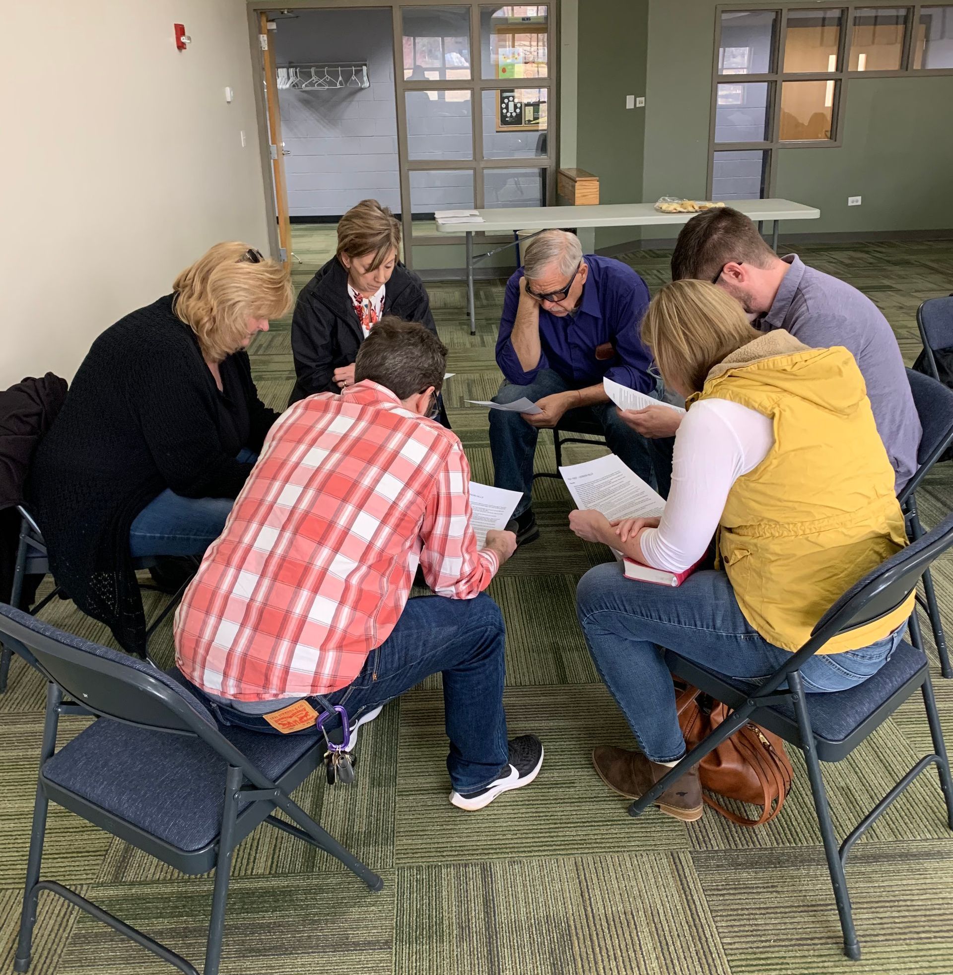 A group of Christians are sitting in a circle praying