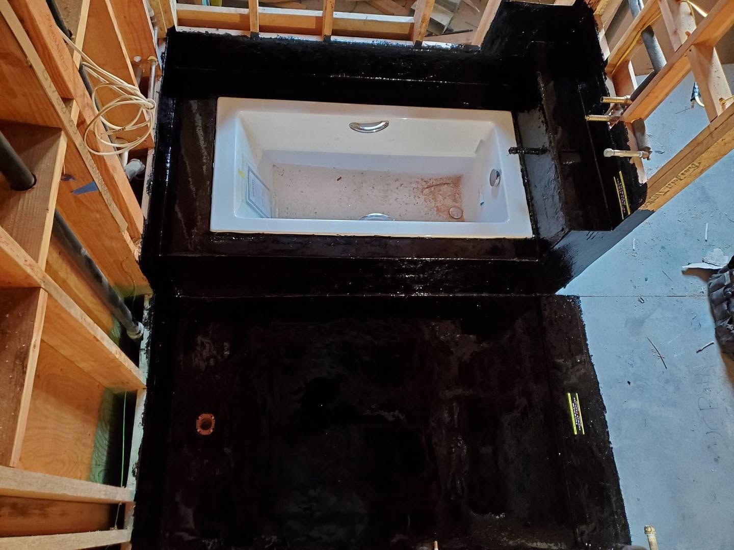 Interior of an unfinished stairwell with wood framing and a black-coated opening at the center