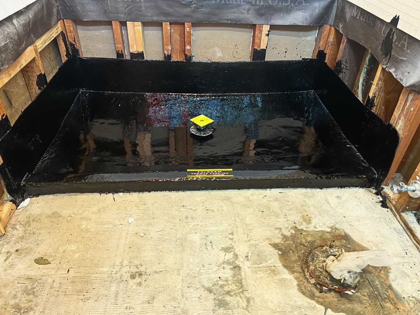 Black-lined concrete tank with standing water and a small yellow float in the center, viewed from above