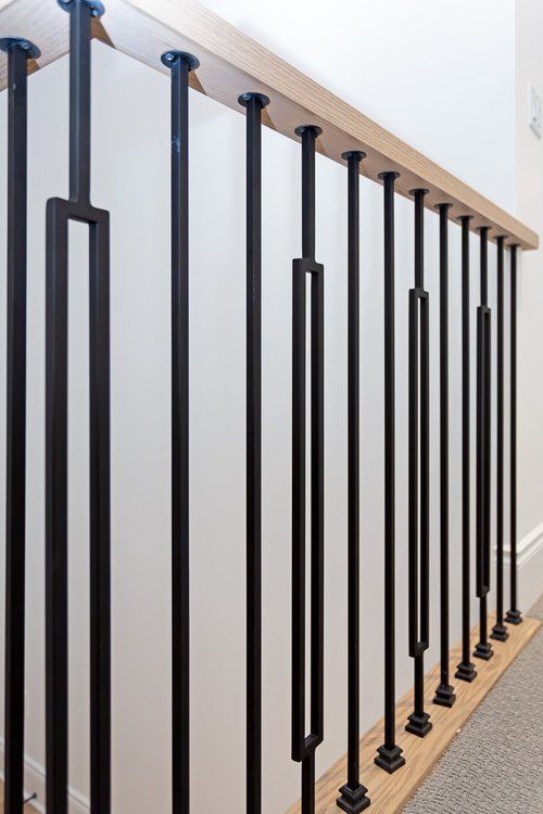A close up of a black railing on a staircase.