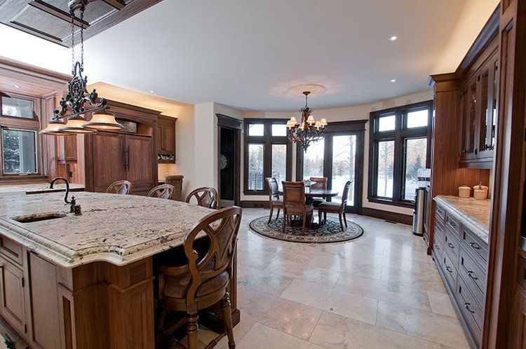 A kitchen with a large island and a dining room in the background.