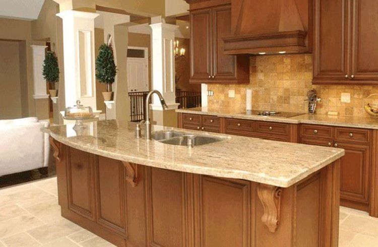 A kitchen with a large island and granite counter tops.