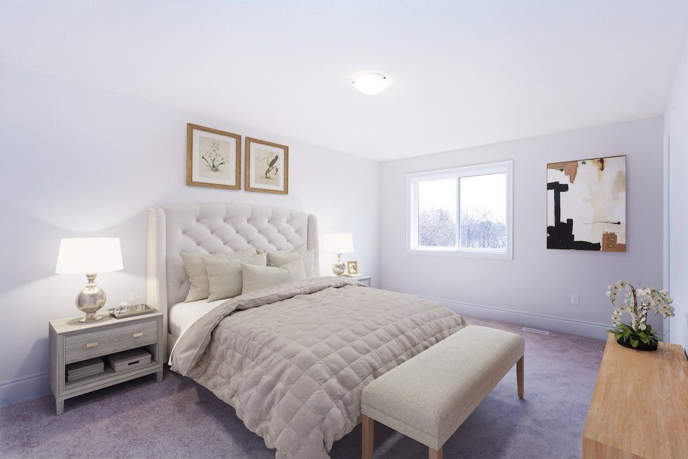 A bedroom with a bed , nightstand , bench and two windows.