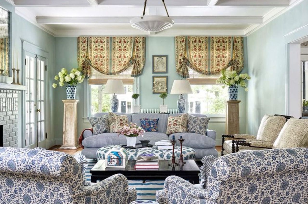 Living room with blue and gold floral patterns, two armchairs, sofa, and window treatments.