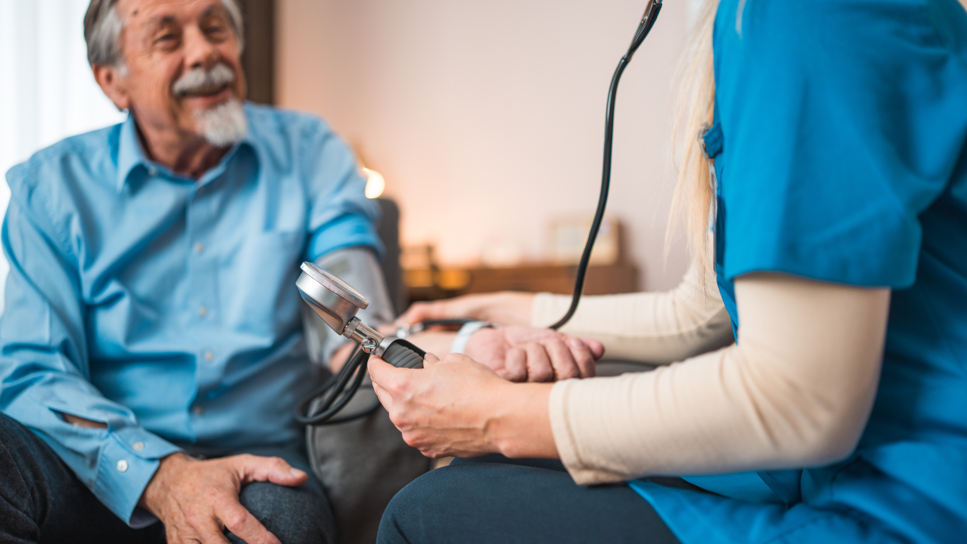 Nurse taking an elderly person's blood pressure with a stethoscope in a home setting.