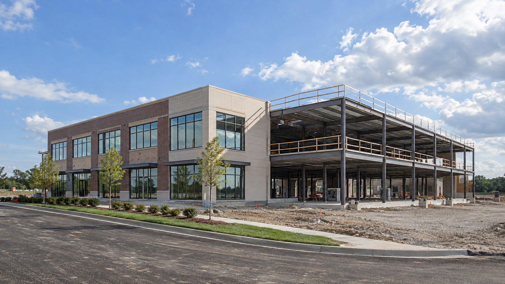 Modern building under construction with steel framework, brick exterior, and paved lot under a blue sky