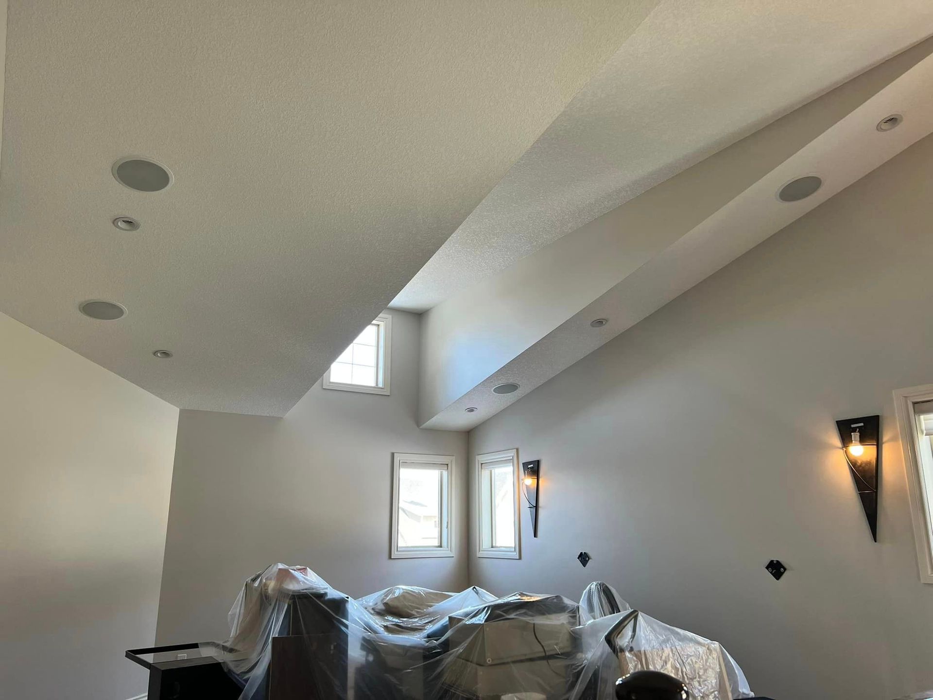 A room with a ceiling that is very high and a lot of windows.