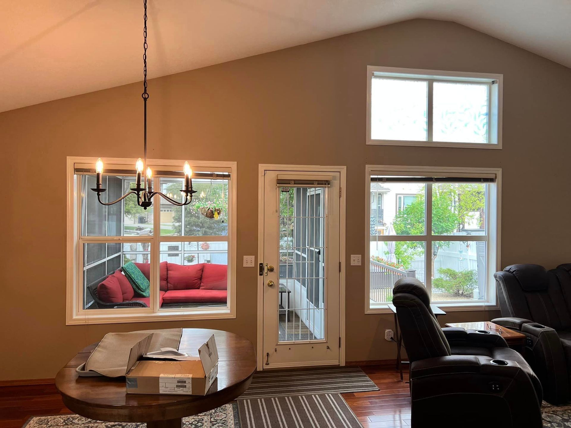 A living room with a table and chairs and a chandelier hanging from the ceiling.