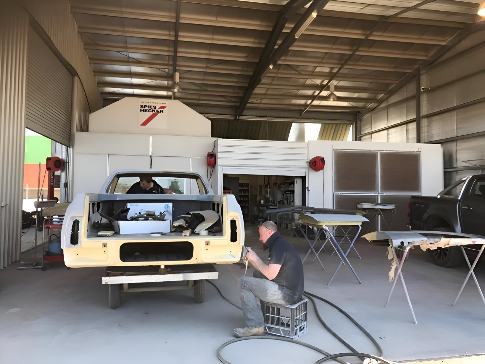 A Man Is Working On A Truck In A Garage — P & V Panel Works In Alice Springs, NT