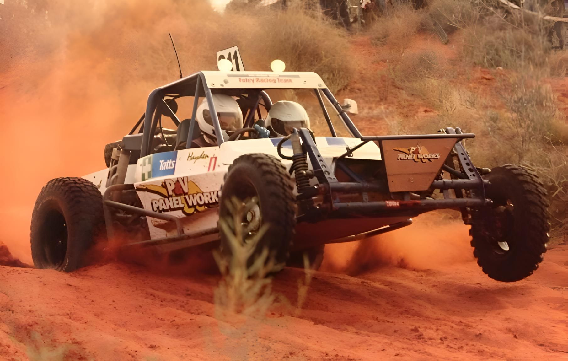 A Dune Buggy Is Driving Down A Dirt Road — P & V Panel Works In Alice Springs, NT