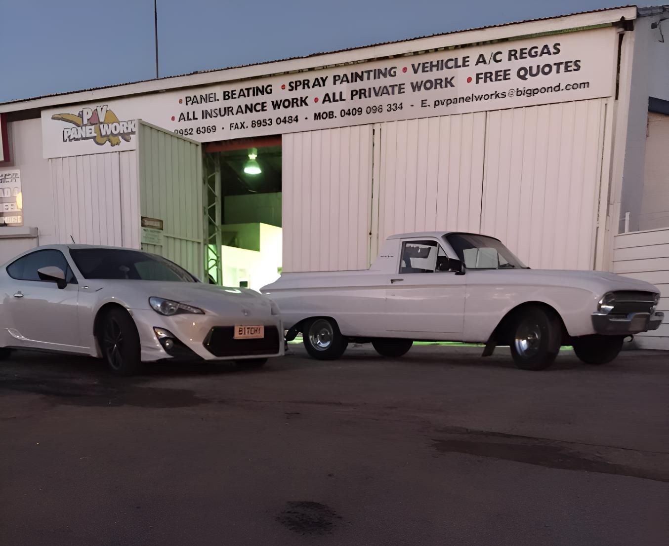Two White Cars Are Parked In Front Of A Building That Says All Insurance Work — P & V Panel Works In Alice Springs, NT