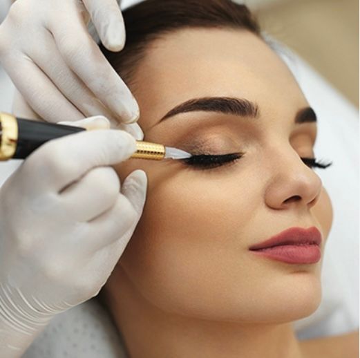 A woman is getting her eyebrows done with a machine