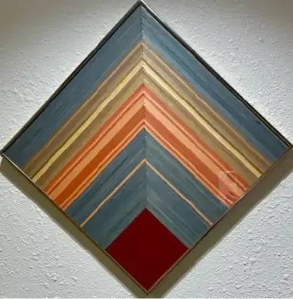Abstract diamond-shaped wall art with layered blue, orange, tan, and red geometric stripes