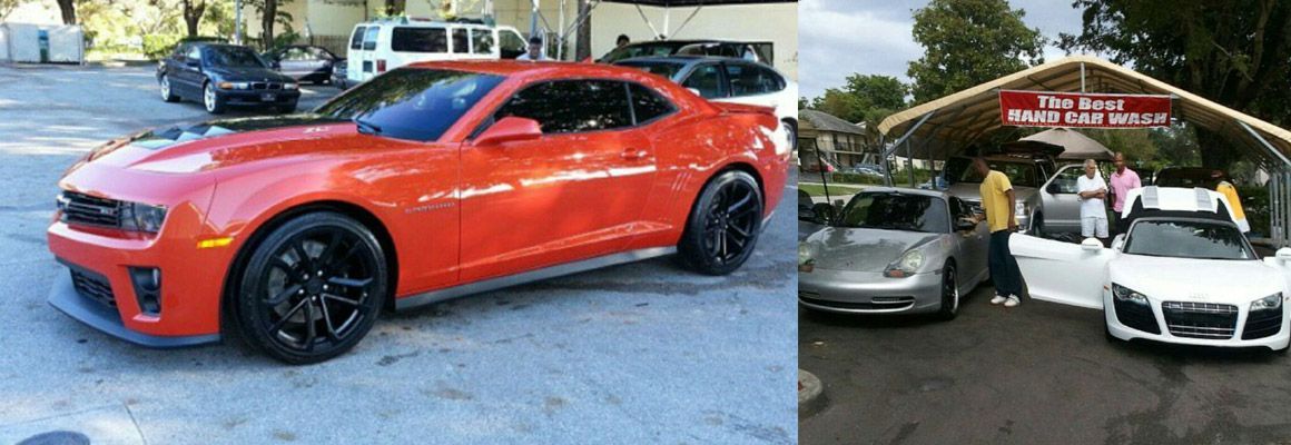 A red car is parked in a parking lot next to a white car.
