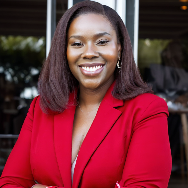 Photo of professional woman wearing a red blazer smiling 