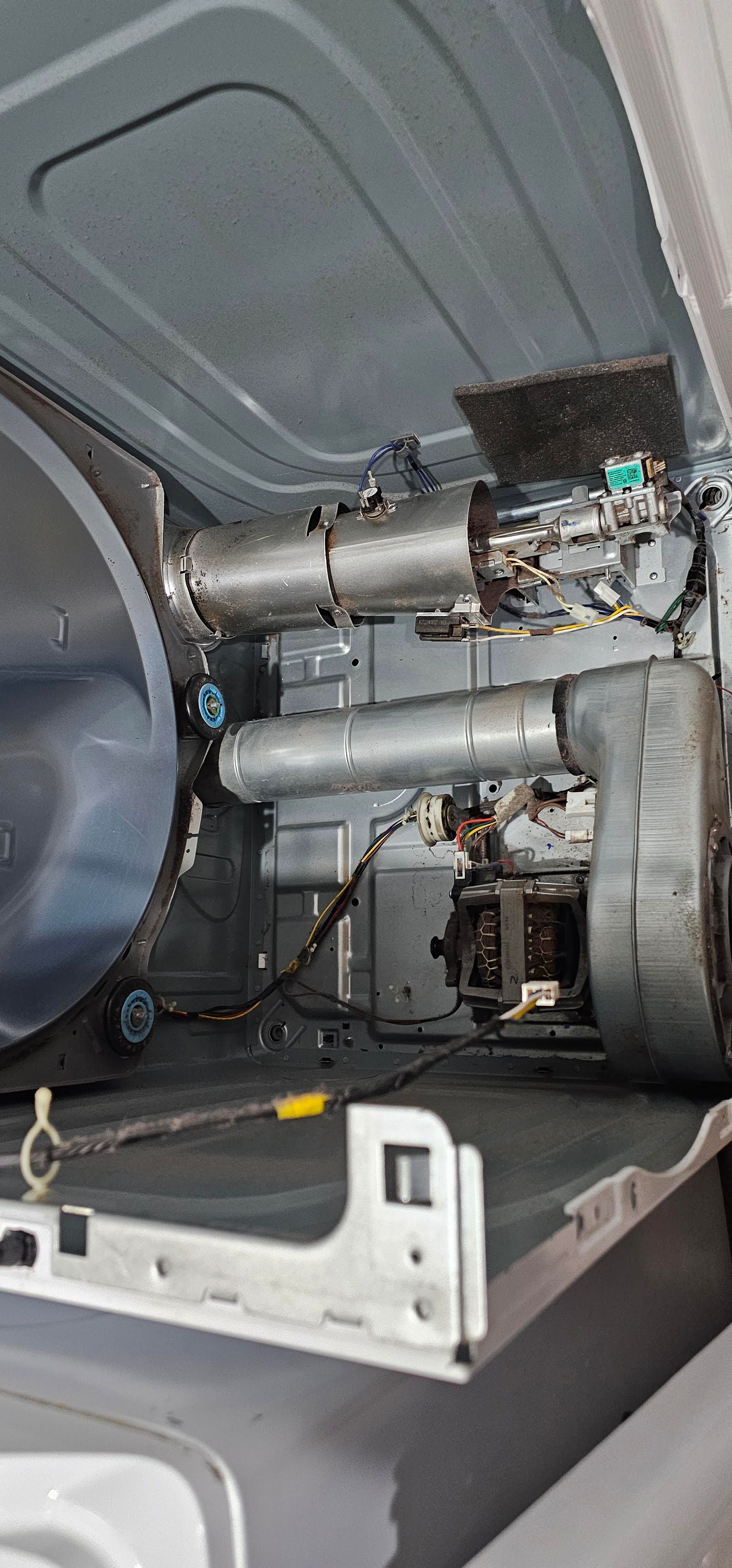 Car trunk interior with exposed panels, wiring, and metal components during repair