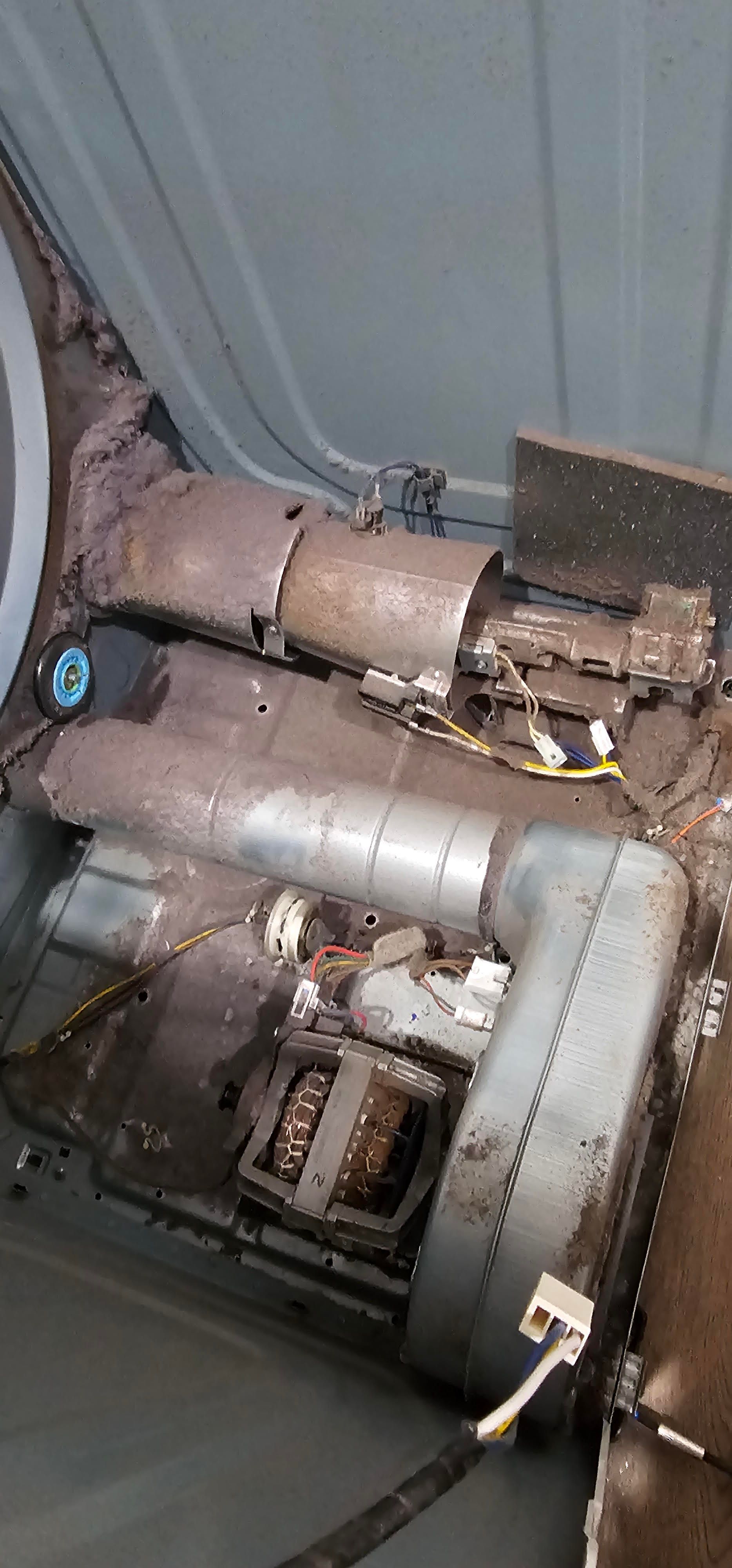 Dirty gray industrial interior with pipes, vents, and mold-stained floor panels