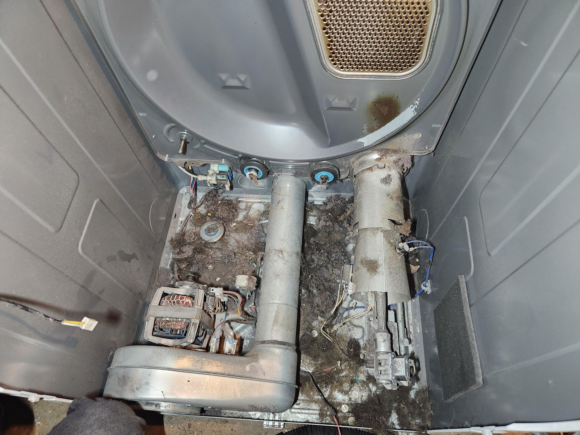 Dirty gray industrial interior with pipes, vents, and mold-stained floor panels