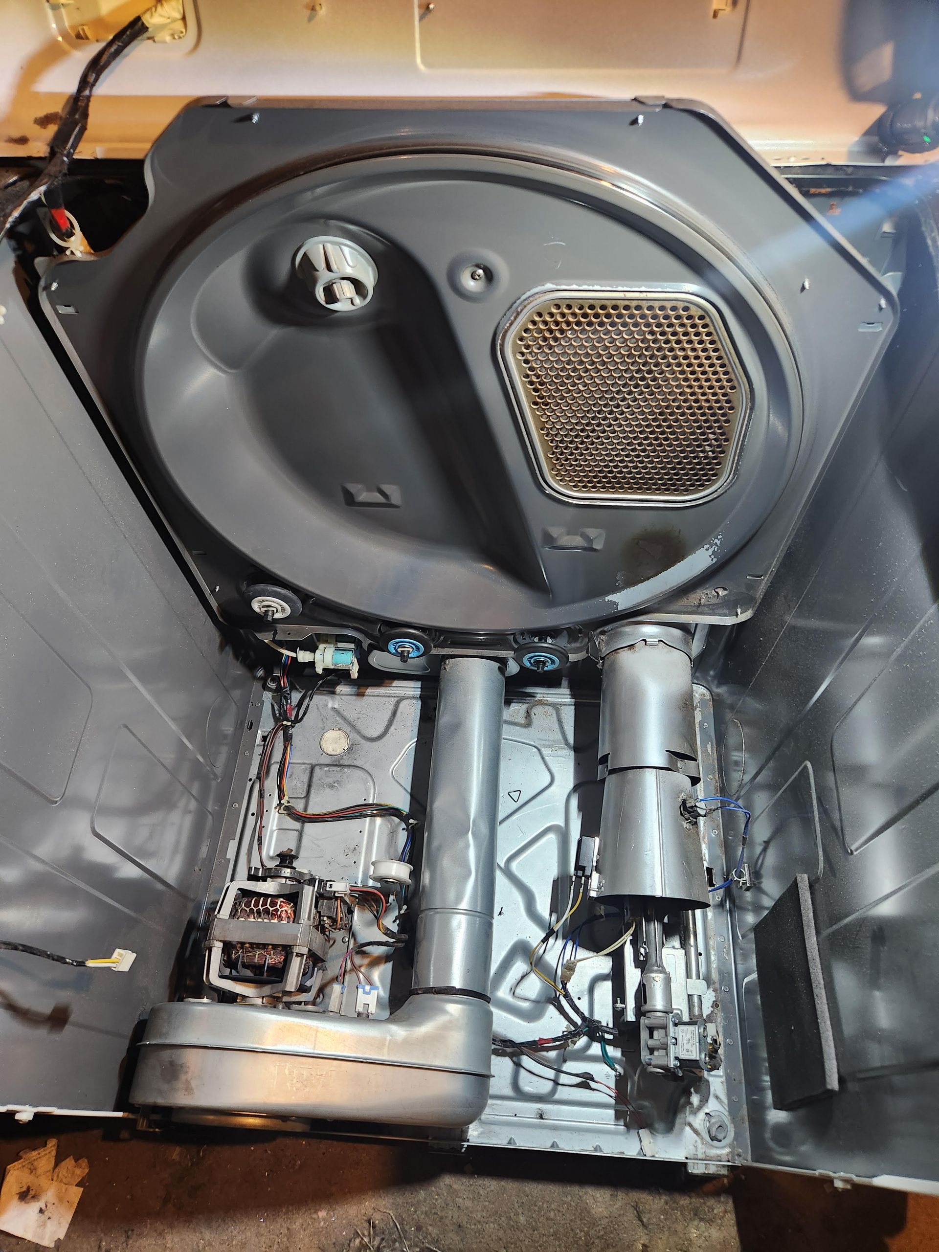 Car trunk interior with exposed panels, wiring, and metal components during repair