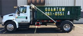 White and green Qwik-style utility truck parked on asphalt, side view with “QUICKW” and phone number on the door.