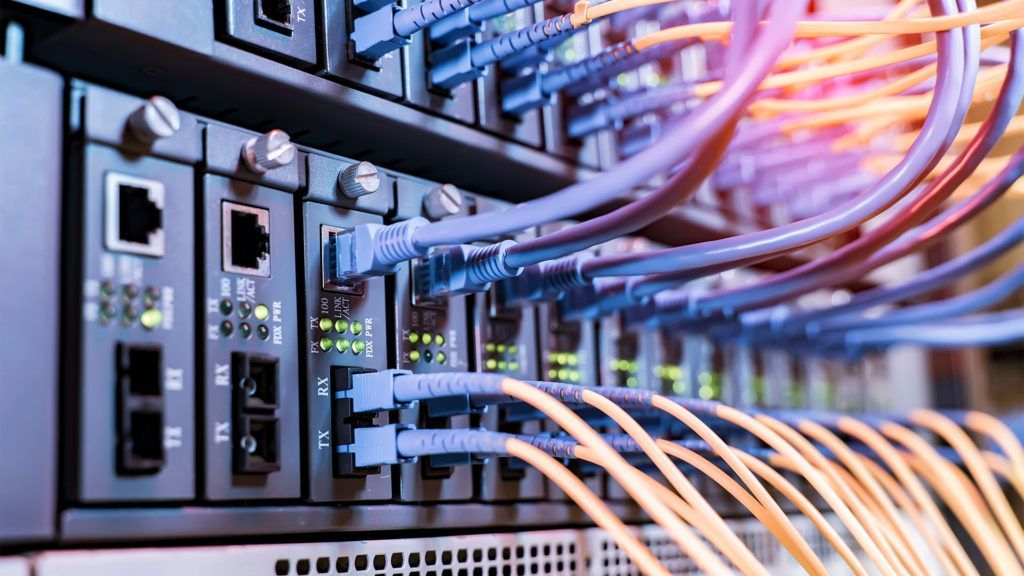 Hardware de servidor de rede com cabos azuis e laranjas.