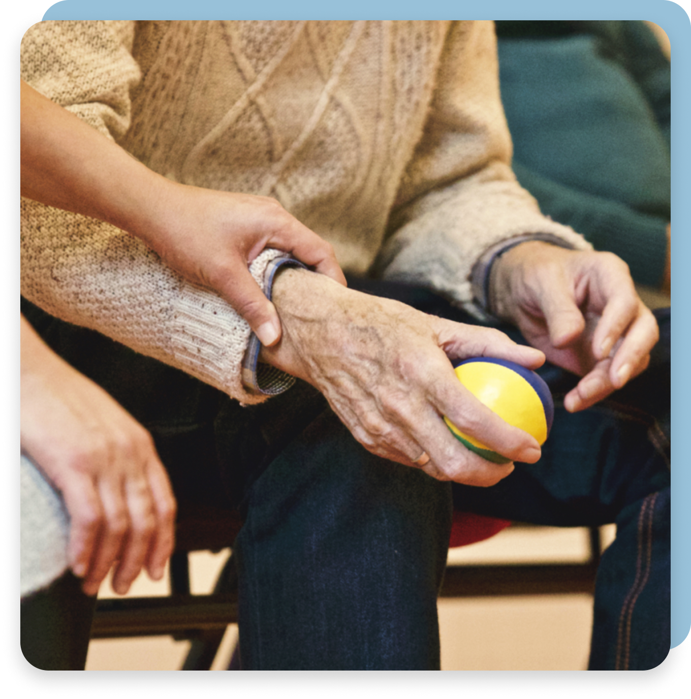 A woman is helping an elderly man with a yellow ball