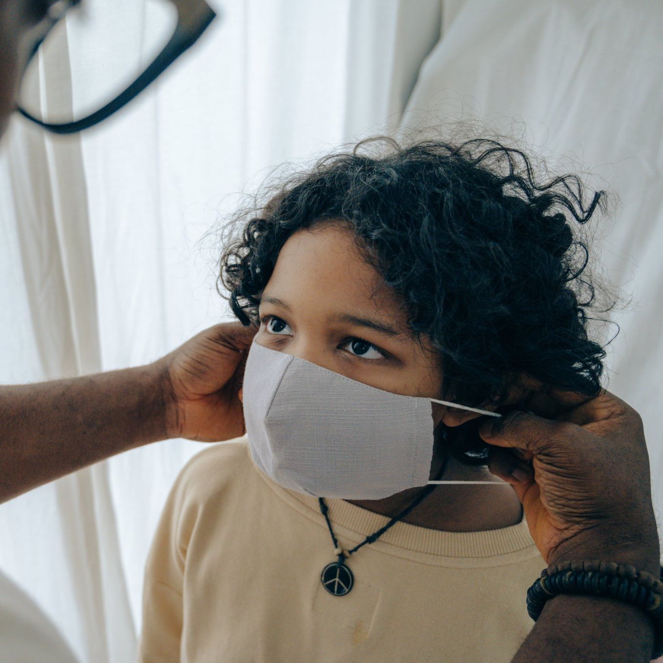 A person is putting a mask on a child 's face