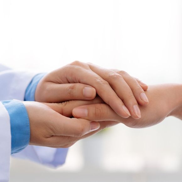 A doctor is holding the hand of a patient.