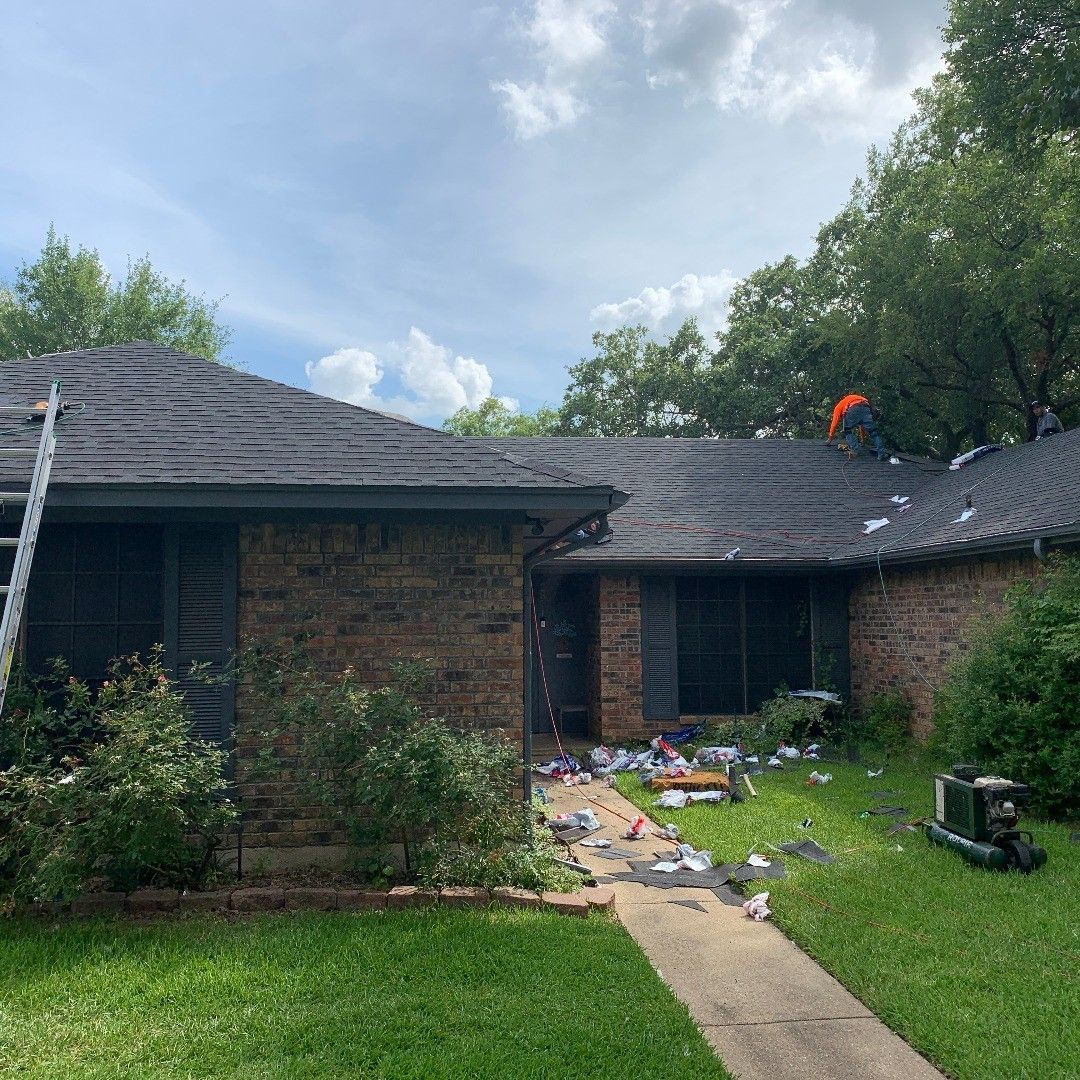 A brick house with a roof that is being repaired.