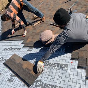 A group of men are working on a roof.