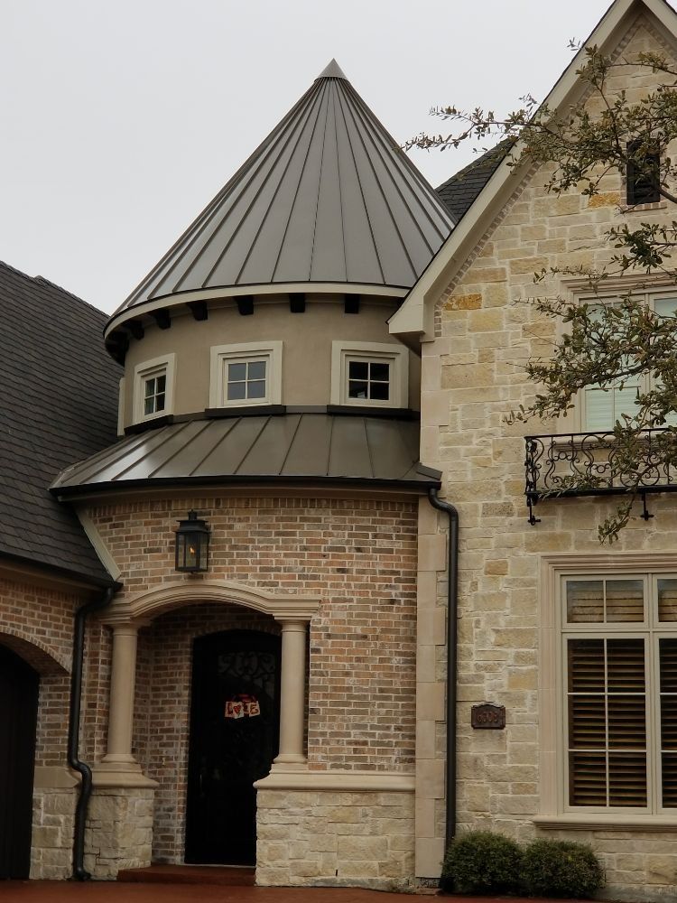 A house with a cone shaped roof and a black door