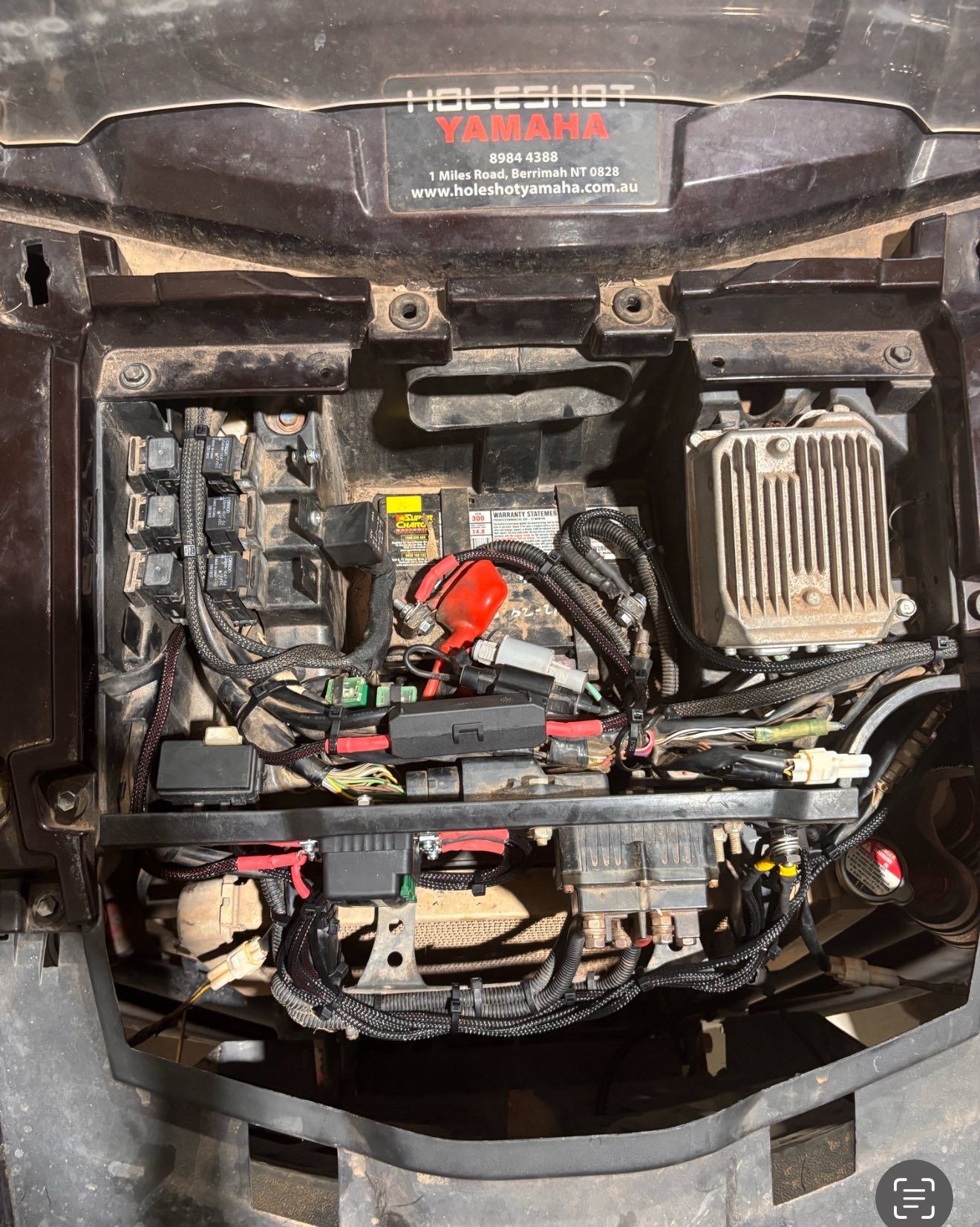 Black ATV compartment with battery, fuses, and wiring. — Prestige Automotive NT In Katherine, NT