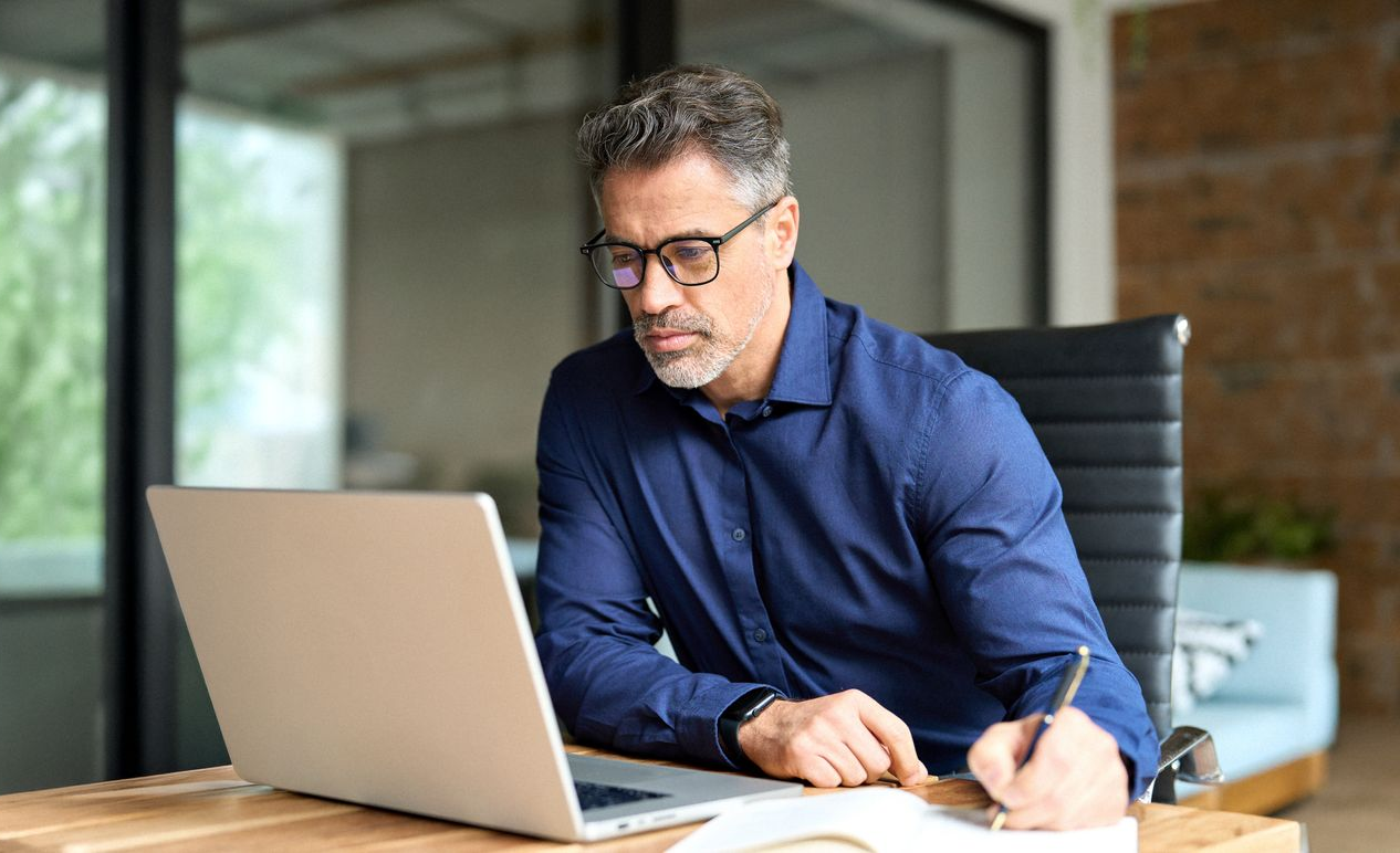 A group of cell phone towers against a cloudy sky.