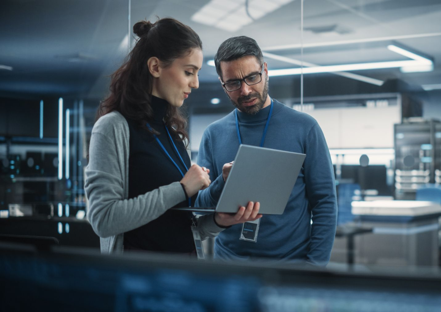 A group of cell phone towers against a cloudy sky.