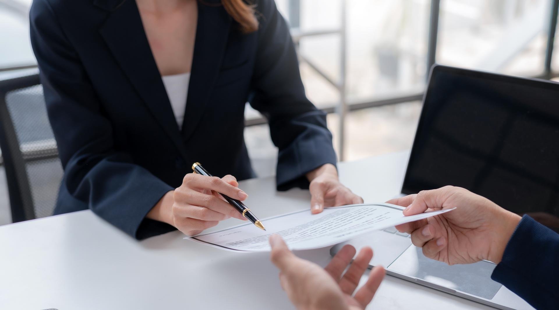 A man and a woman are sitting at a table looking at a piece of paper.
