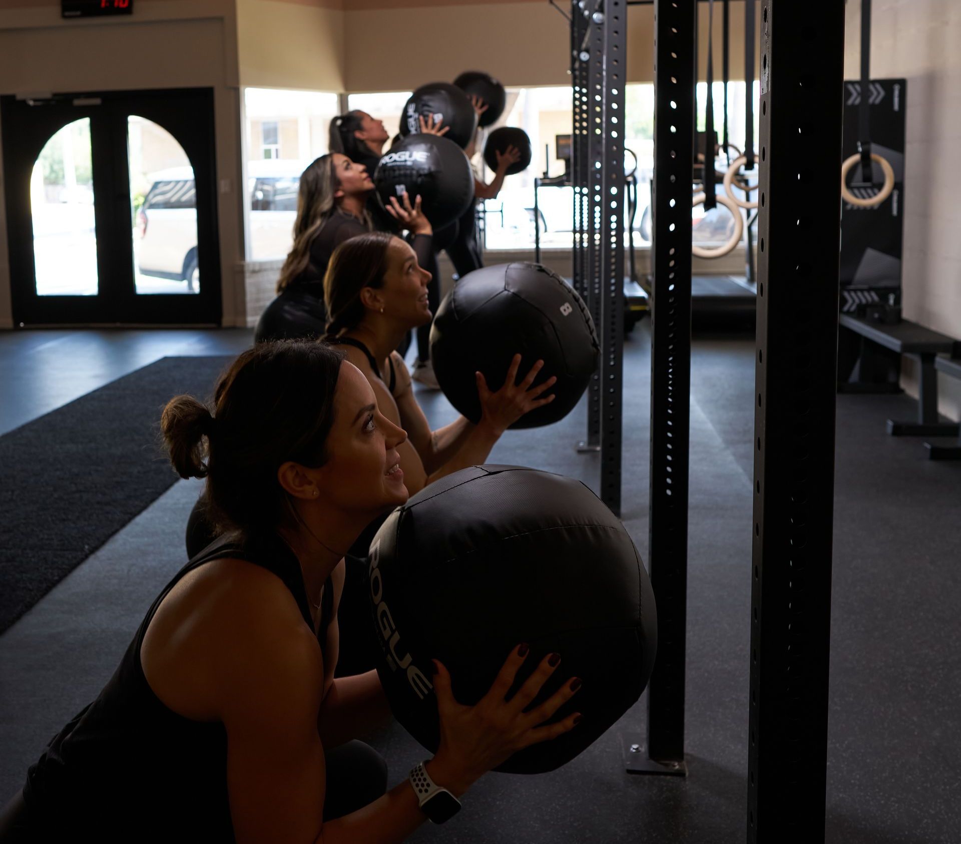 A group of women are lifting dumbbells in a gym.