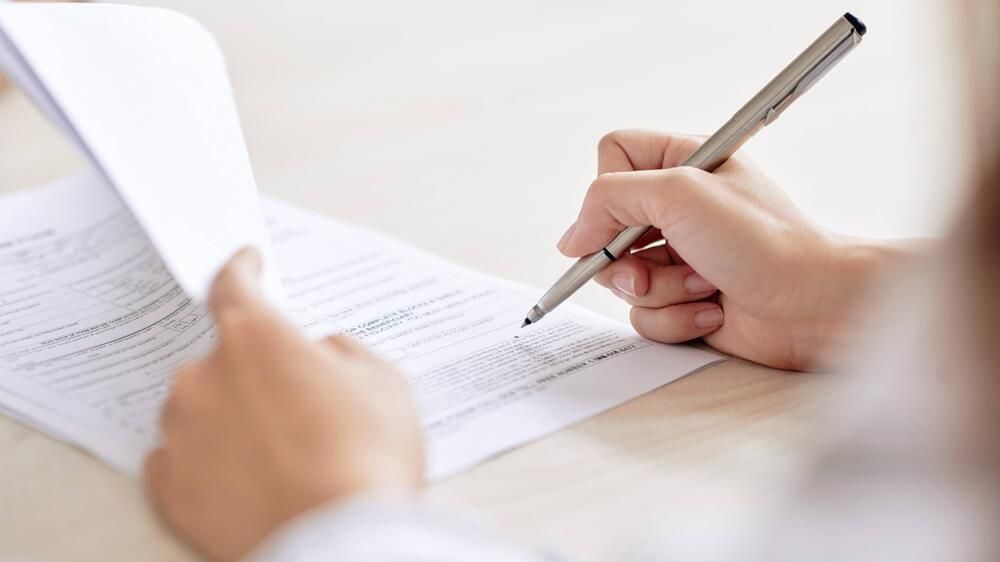 A person filling out bond forms