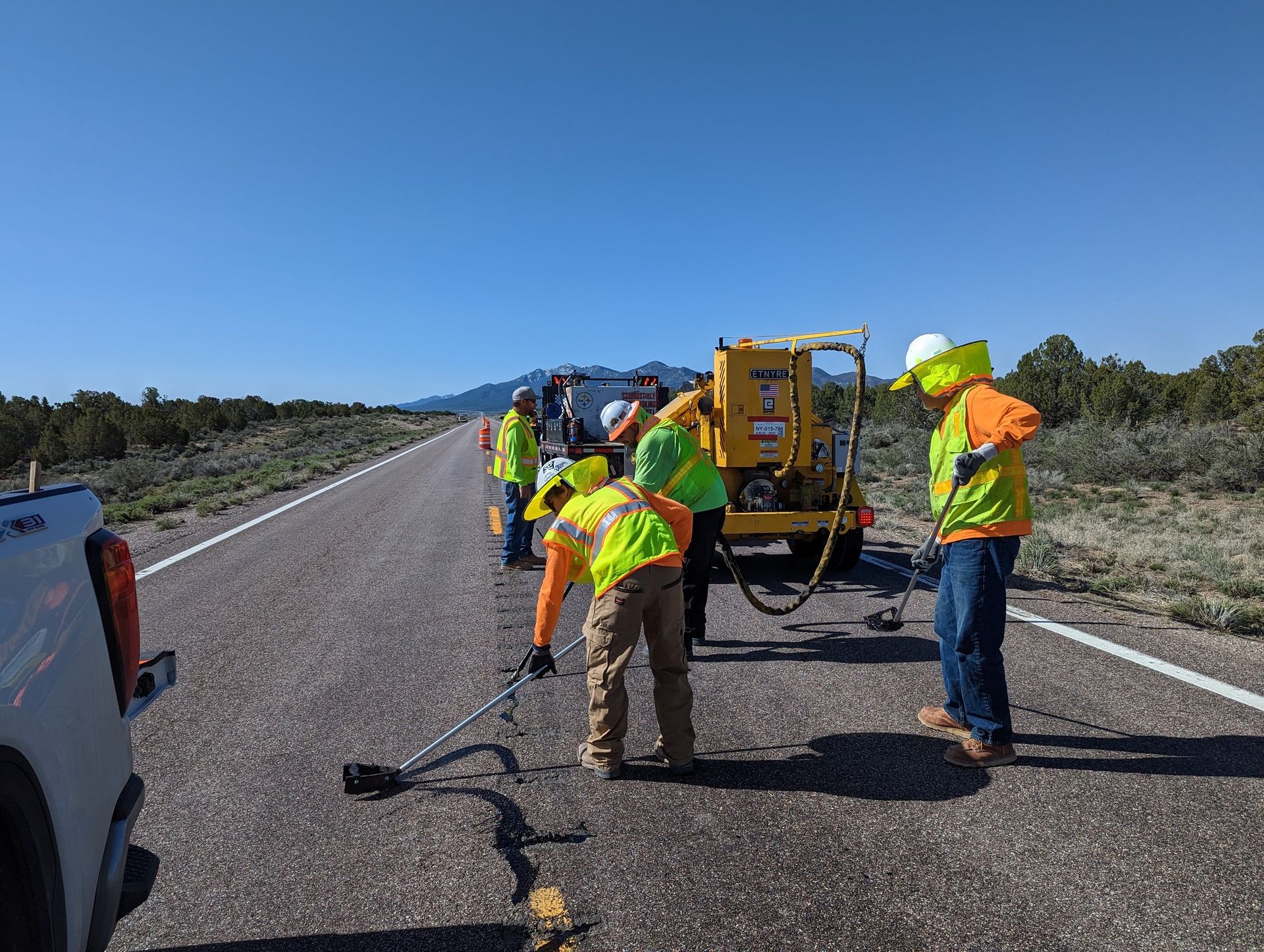 A group of construction workers are sealing cracks in the road Nevada.
