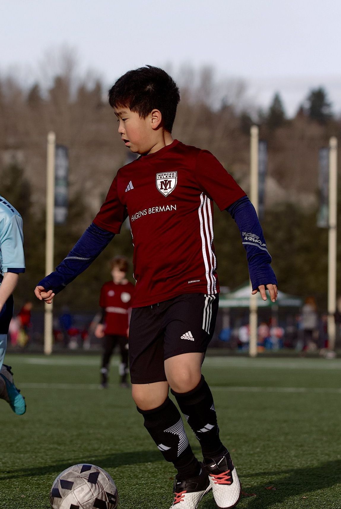 Soccer player in red jersey controls the ball on a field during a match