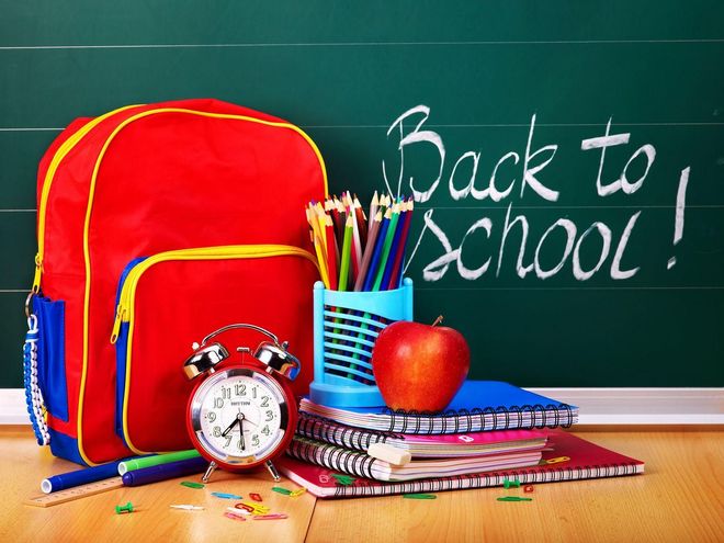 Back-to-school scene with red backpack, school supplies, apple, clock, and chalkboard text