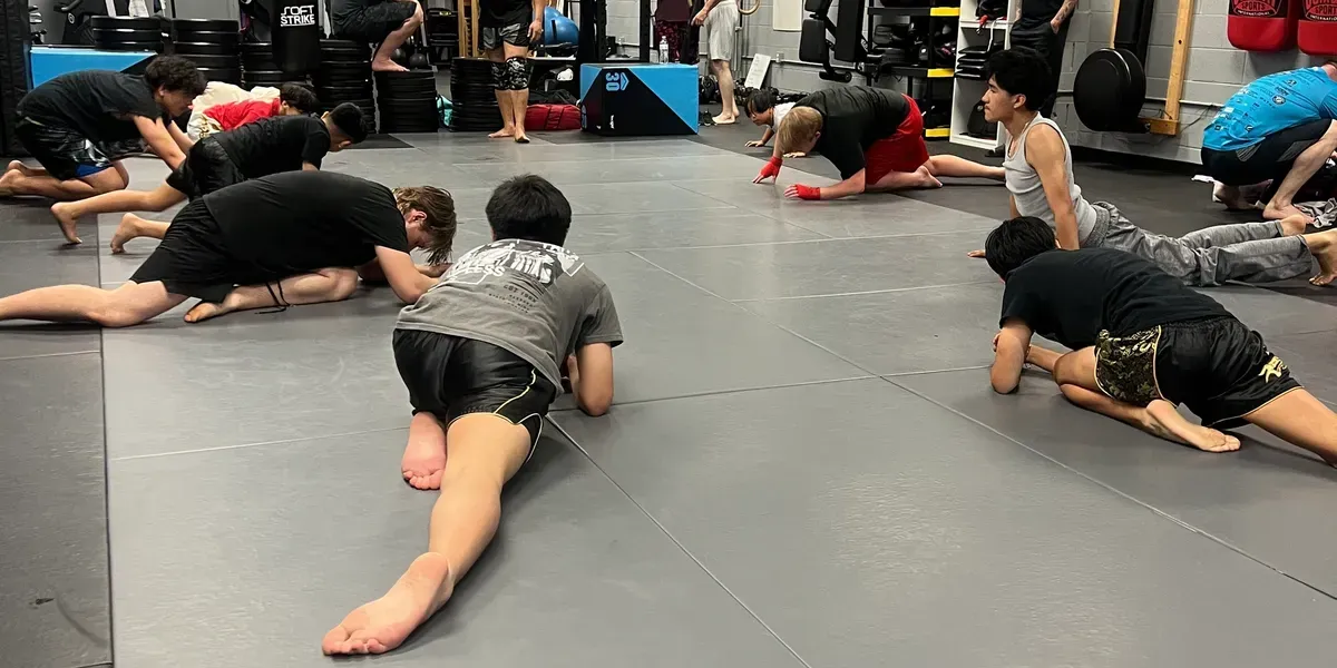 People stretching on mats in a gym in Murfreesboro, TN, doing floor exercises in a group class