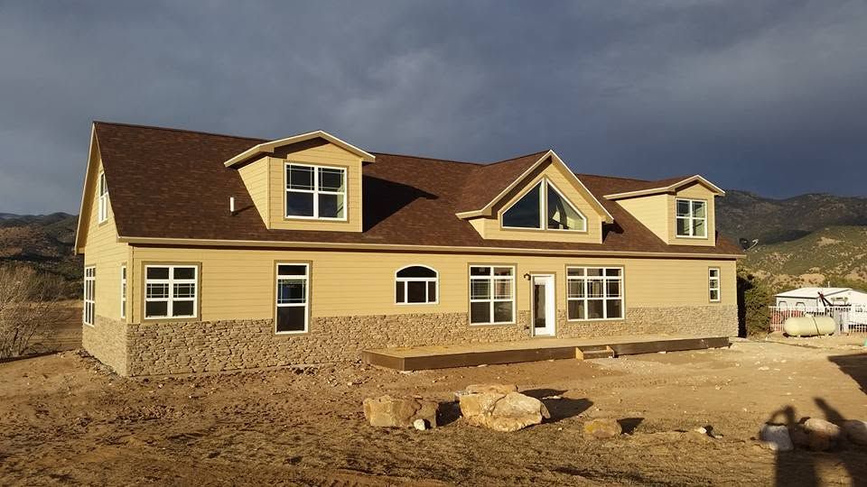 New beige house under construction in a desert landscape with mountains in the background