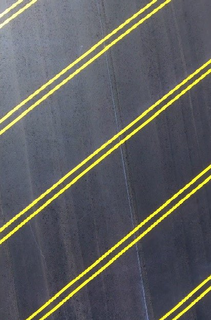 An image of a man wearing a puffy jacket and a backpack running across a crosswalk with thick white lines.