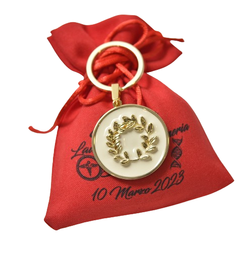 Borsa rossa con ciondolo bianco con bordo dorato raffigurante una corona d'alloro dorata. Un portachiavi fissa il ciondolo alla borsa.